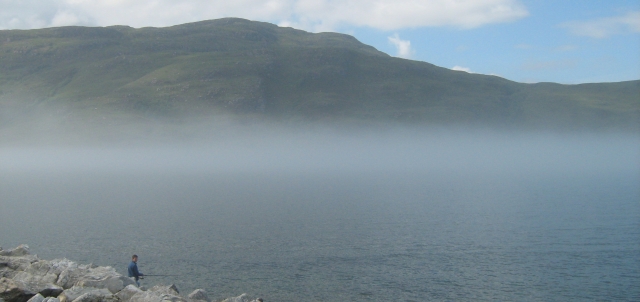 mist lying low on the water with the mountins in the clear at loch broom
